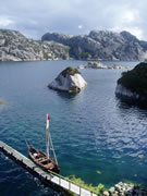 faering at jetty in fjord with island